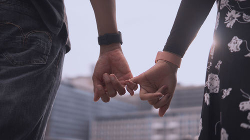 Midsection of couple holding hands