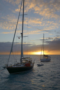 Sailboat sailing on sea against sky during sunset