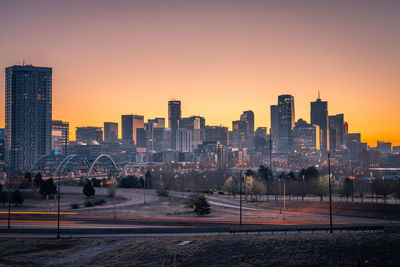 Silhouette modern buildings against sky during sunset