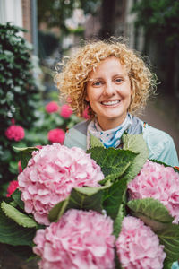 Portrait of smiling young woman with bouquet