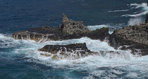 Waves breaking on rocks in sea