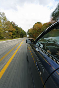 Close-up of car in speed on road against sky