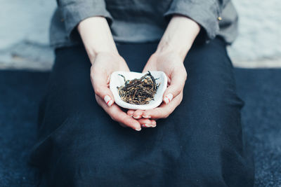 Midsection of woman holding herbs