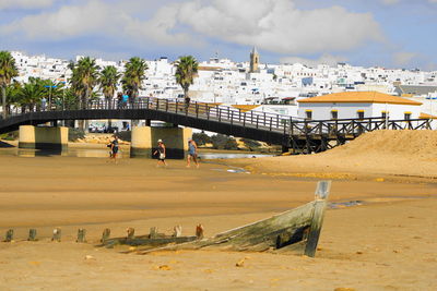 View of bridge and buildings against cloudy sky