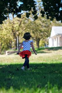 Rear view of girl running on field