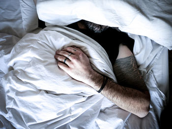 Midsection of man sleeping on bed