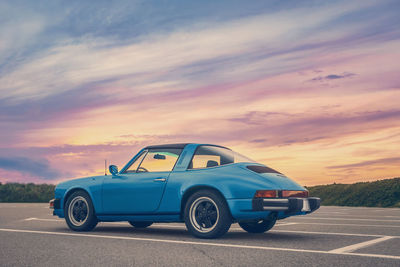 Vintage car on road against sky during sunset