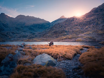 Scenic view of lake against mountains during sunset