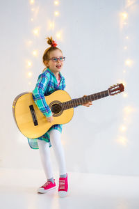 Low angle view of girl playing guitar