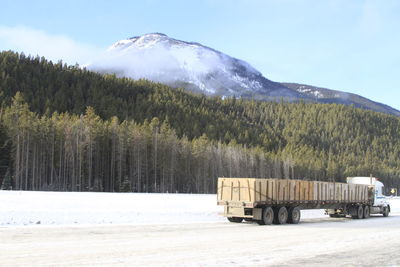 Scenic view of snowcapped mountains  and truck against sky in banff canada