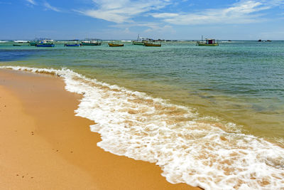 Fishing boats anchored in the waters of the famous itapua beach in salvador, bahia