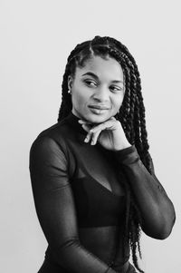 Portrait of smiling young woman against white background