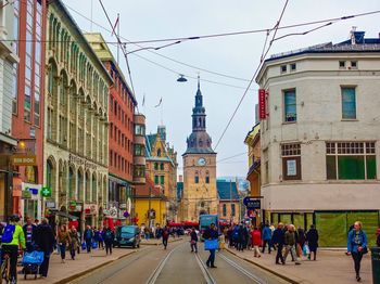 People walking on street amidst buildings in city