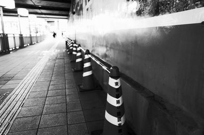 People on footpath against illuminated wall