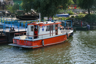 Boat moored on river against trees