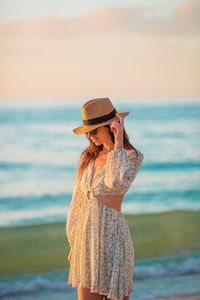 Rear view of woman standing at beach