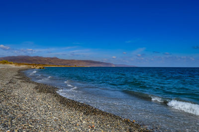 Scenic view of beach against blue sky