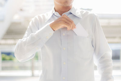 Midsection of man standing with envelope