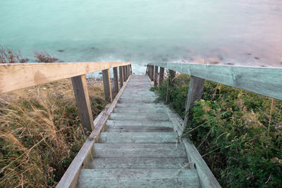 High angle view of footbridge leading towards sea