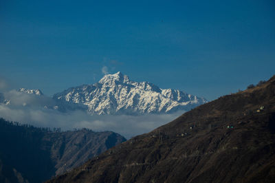 Scenic view of snowcapped mountains against blue sky