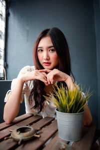 Portrait of young woman sitting on table