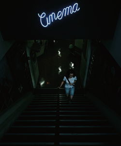 Low angle view of woman on illuminated staircase
