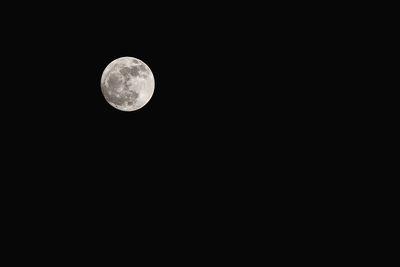 Low angle view of full moon against sky at night