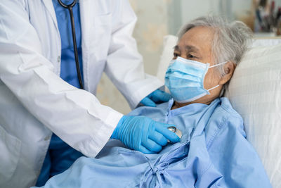 Midsection of doctor examining woman at hospital