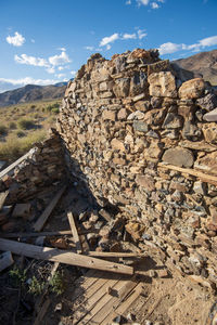 Scenic view of rocky ruins of stone cabin in desert against sky