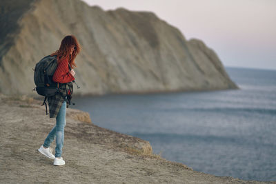 Rear view of woman on rock at beach