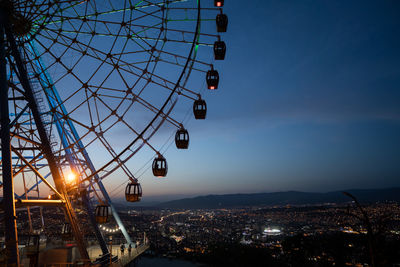 Ferris wheel in mtatsminda amusement park in tbilisi, georgia. illuminated giant wheel at night