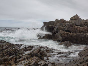 Scenic view of rocks in sea against sky