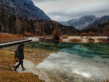 Rear view of man on lake against sky