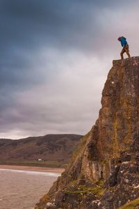 Man on rock against sky