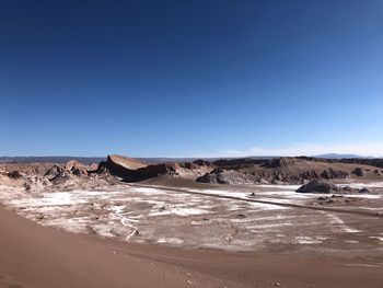 Scenic view of desert against clear blue sky