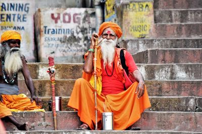 Rear view of men sitting on street in city