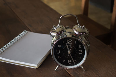 High angle view of alarm clock by diary on table