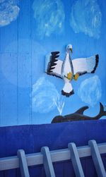 Birds on wood against blue water