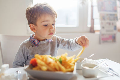 Boy eating food on table