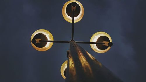 Low angle view of illuminated street lights against sky during dusk