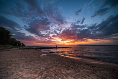 Scenic view of beach against sky during sunset