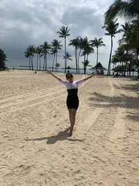 Full length of young woman standing on beach