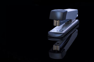 Close-up of stapler against black background