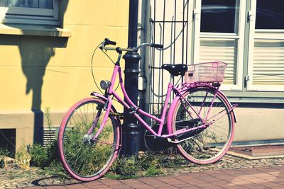 Bicycle parked on sidewalk by building
