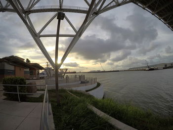 Bridge over river against sky in city