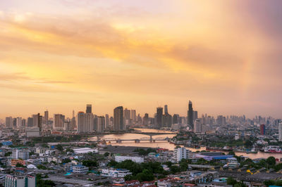 Modern buildings in city against sky during sunset