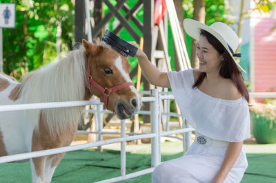 Midsection of woman with white horse