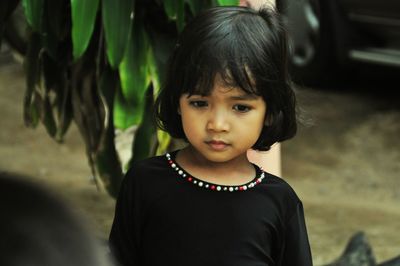 Thoughtful cute girl standing on field