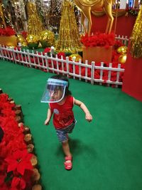 Rear view of child standing by red umbrella