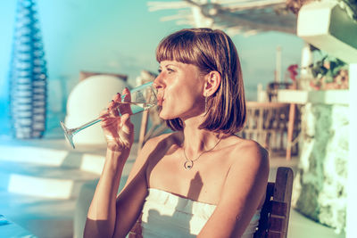 Portrait of young woman drinking outdoors